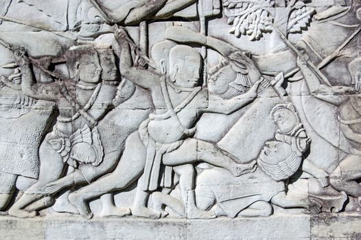 Ancient Khmer bas relief carving showing a Khmer soldier about to kill a Cham soldier. Outer wall of Bayon Temple, part of the Angkor Thom complex, Siem Reap, Cambodia.
