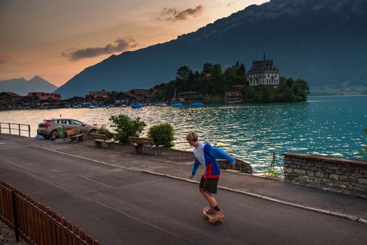Iseltwald, Switzerland - July 21, 2019 : Young skater skateboarding in the village of Iseltwald along the Lake Brienz.