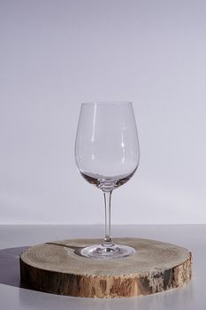 Glass of wine on white background, high key, wooden stump