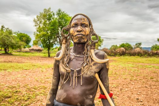 OMO VALLEY, ETHIOPIA - MAY 7, 2015 : Warrior from the african tribe Mursi with traditional horns in Mago National Park, Ethiopia.