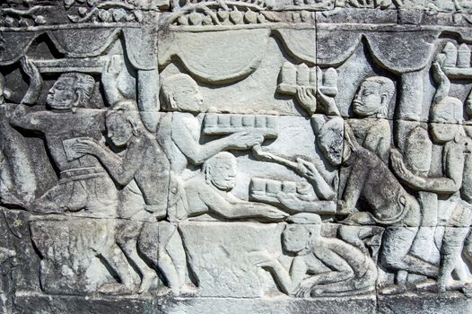 Ancient Khmer carving showing trays of food and drink being carried to a banquet. Wall of Bayon Temple, Angkor Thom, Siem Reap, Cambodia.
