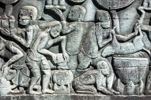 Ancient bas relief carving showing Khmer people cooking. Frieze at Bayon Temple, Angkor Thom, Siem Reap, Cambodia.