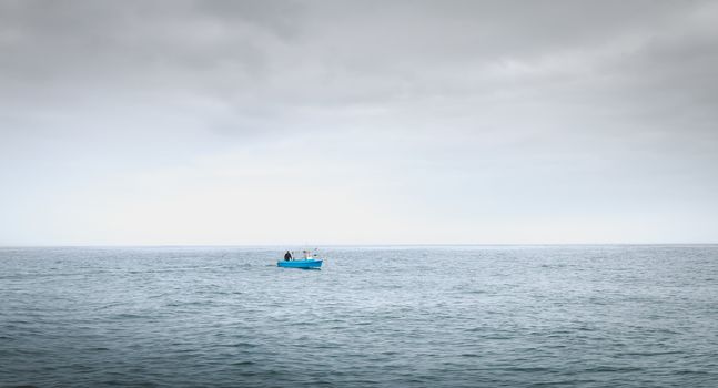 Port Joinville, France - September 18, 2018: Small blue fishing boat sailing on the coast near Port Joinville harbor on Yeu island on a summer day