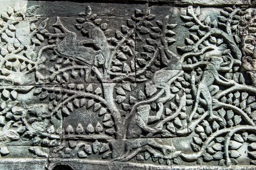 Ancient Khmer bas relief showing monkeys playing in the branches of a tree. Frieze on southern gallery of Bayon Temple, Angkor Thom, Siem Reap, Cambodia