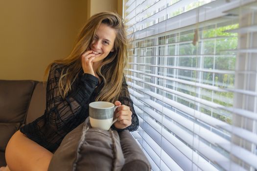 A gorgeous brunette model poses in lingerie in a home environment