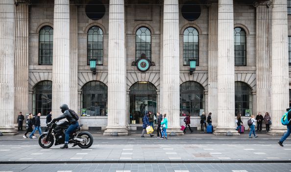 Dublin, Ireland - February 12, 2019: Architecture detail of the Central Post Office in the historic city center where people walk on a winter day