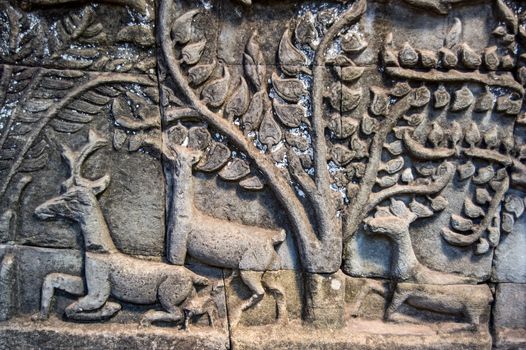 Ancient bas relief carving showing deer in a forest. Wall of Bayon Temple, Angkor Thom, Siem Reap, Cambodia.