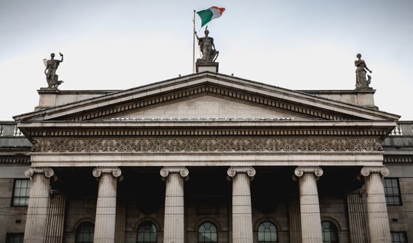 Dublin, Ireland - February 12, 2019: Architecture detail of the Central Post Office in the historic city center where people walk on a winter day