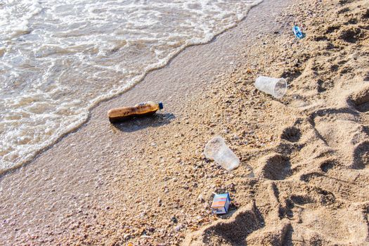 Plastic bottle and other pollution garbage on the beach at caused by much volume tourists popular tourist destination.
