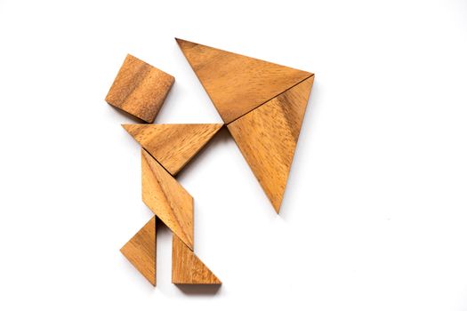 Wooden tangram as man hold umbrella shape on white background (Concept as business has the crisis)