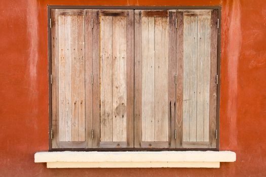 Old wooden window on orange color concrete background