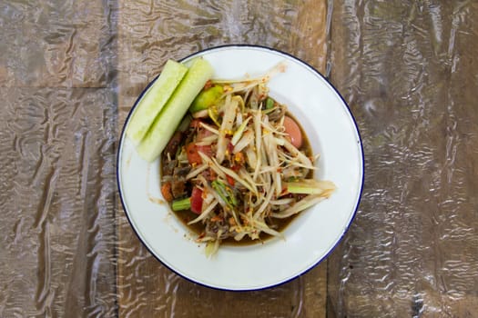 Thai papaya sald (Somtum) on wooden background