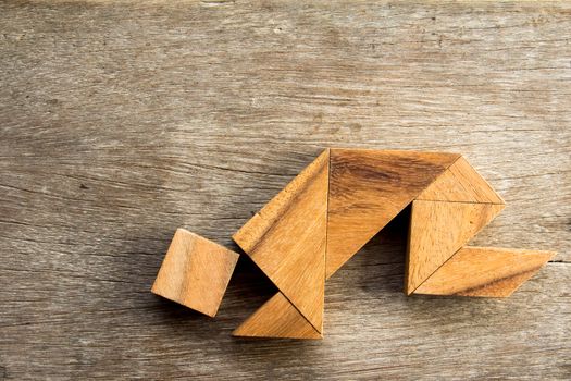 Wooden tangram puzzel in man crouch shape background