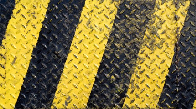 Black and yellow line paint on non-slip metal background