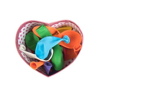 Colorful deflated balloons in heart box on white background