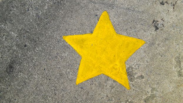 Yellow painting star on concrete texture background