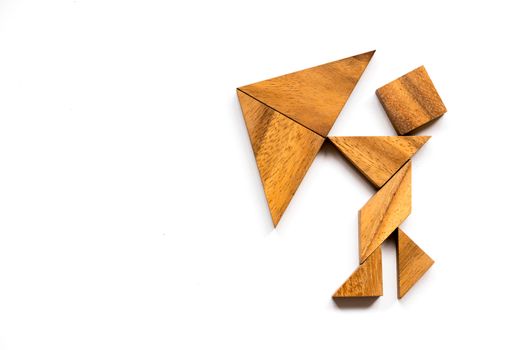 Wooden tangram as man hold umbrella shape on white background (Concept as business has the crisis)