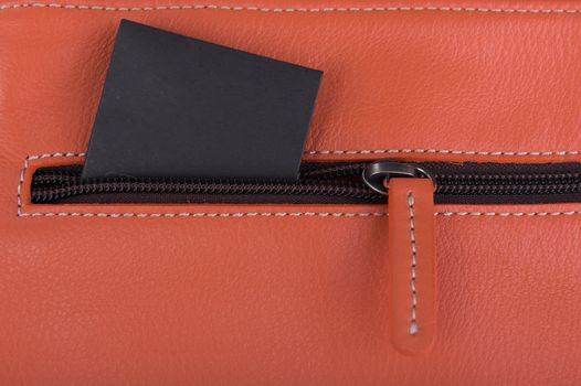 Close up orange leather bag with black label