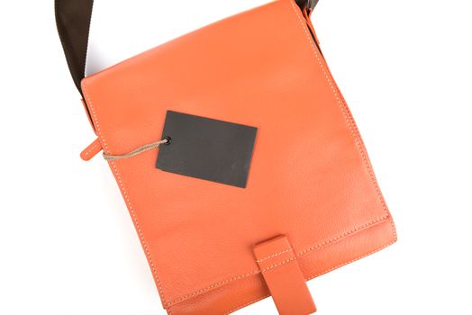 Orange leather bag with black price tag on white background