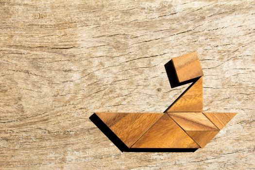 Wooden tangram puzzle as man thinking on boat shape