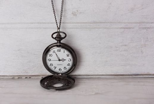 Classic pocket watch on white grune wooden background 