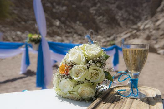 Setup of wedding day marriage ceremony with flower bouquet and champagne in remote arid desert environment