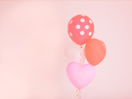 Fastive heart shape balloons on pink wall with vintage filter effect