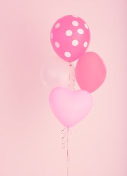 Fastive heart shape balloons on pink wall with vintage filter effect