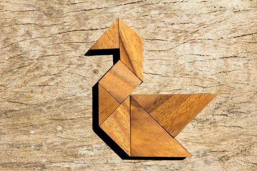 Wooden tangram puzzle in swan shape background