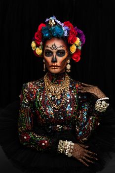 Closeup portrait of a woman with a sugar skull makeup dressed with flower crown. Halloween concept