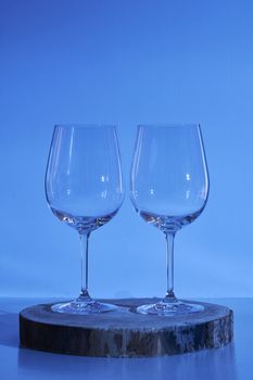 Two glasses of wine on white background, cold tone, wooden stump