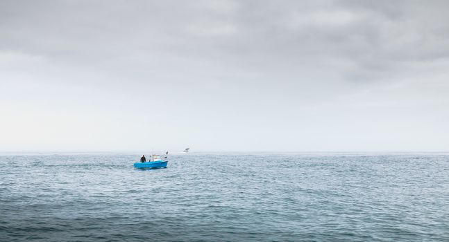 Port Joinville, France - September 18, 2018: Small blue fishing boat sailing on the coast near Port Joinville harbor on Yeu island on a summer day