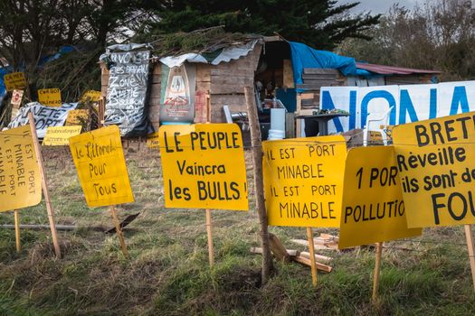 Bretignolles sur Mer, France - October 9, 2019: Set of yellow sign on a protest zone in an area to defend ZAD (Acronym of Zone to Defend) against the construction of the boat harbor