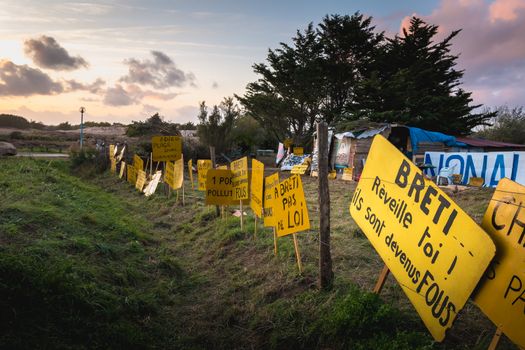 Bretignolles sur Mer, France - October 9, 2019: Set of yellow sign on a protest zone in an area to defend ZAD (Acronym of Zone to Defend) against the construction of the boat harbor