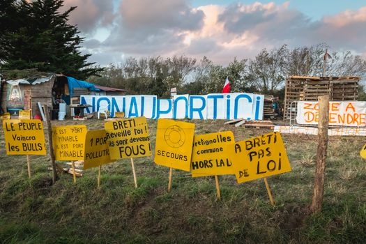 Bretignolles sur Mer, France - October 9, 2019: Set of yellow sign on a protest zone in an area to defend ZAD (Acronym of Zone to Defend) against the construction of the boat harbor