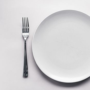 Empty plate and cutlery as mockup set on white background, top tableware for chef table decor and menu branding design