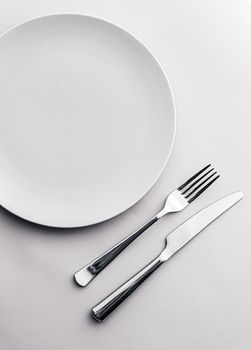 Empty plate and cutlery as mockup set on white background, top tableware for chef table decor and menu branding design