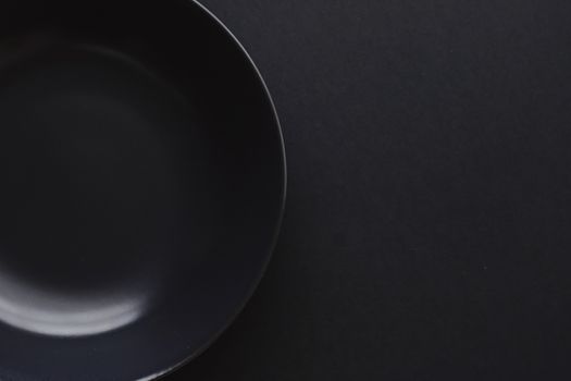 Empty plates on black background, premium dishware for holiday dinner, minimalistic design and diet concept