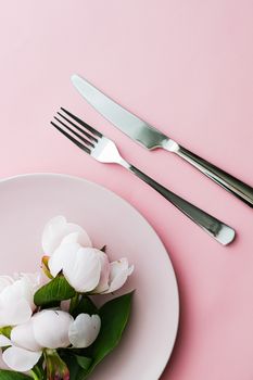 Dining plate and cutlery with peony flowers as wedding decor set on pink background, top tableware for event decoration and menu branding design