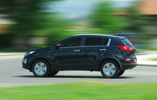 A panning shot of a speeding SUV