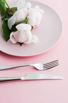 Dining plate and cutlery with peony flowers as wedding decor set on pink background, top tableware for event decoration and menu branding design