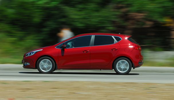 A panning shot of a speeding red car