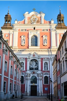 facade of the baroque church decorated with columns and statues in Poznan