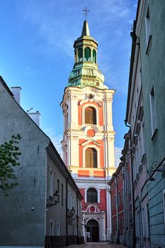 narrow street and belfry of the baroque church in Poznan