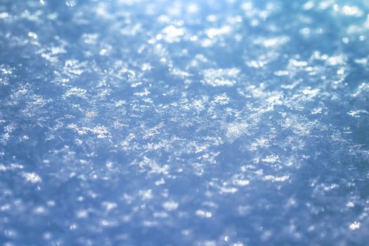 Macro background of fresh snowflake texture on a blur.