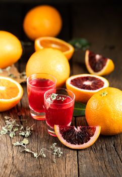 Sliced Sicilian Blood oranges fruits over old dark wooden background. Top view.