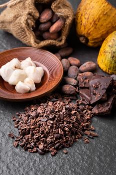 Cocoa beans and cocoa pod on a wooden surface.