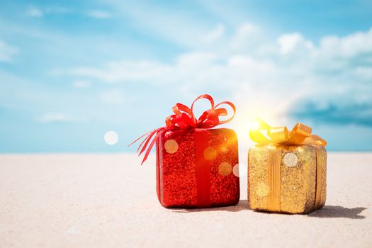 Gift boxes on sandy beach. Hot tours or holiday vacation concept with summer sea background.