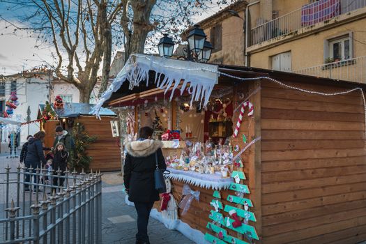 Marseillan, France - December 30, 2018: Street atmosphere in the Christmas market of the city where people walk on a winter day