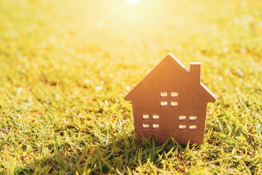 Closed up tiny home model on green grass with sunlight background.